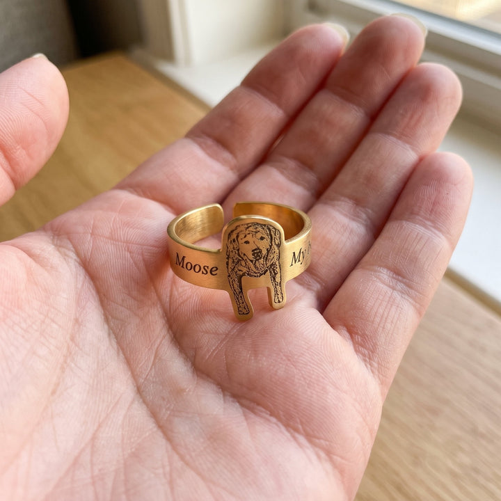 adjustable ring engraved with a pet portrait, held in a hand to show true size