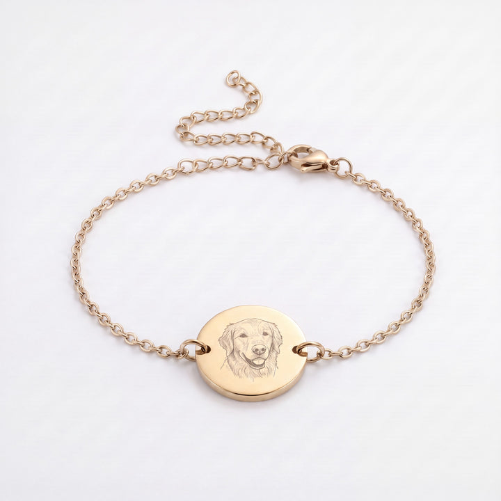 Gold chain bracelet with a round disc engraved with a golden retriever line drawing