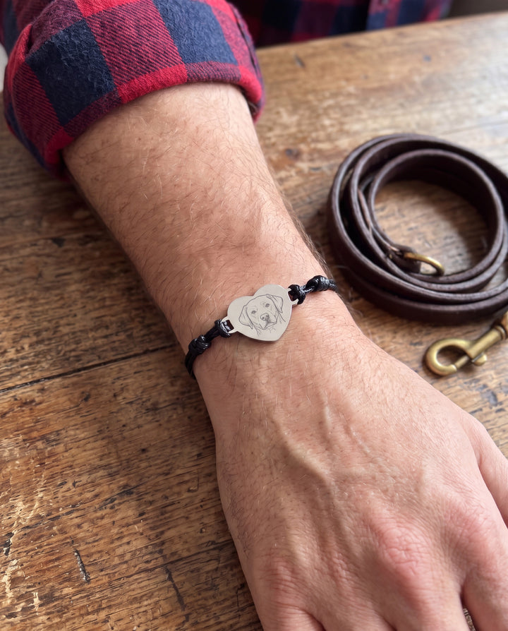 Man wearing the black cord pet portrait bracelet with a Labrador engraving