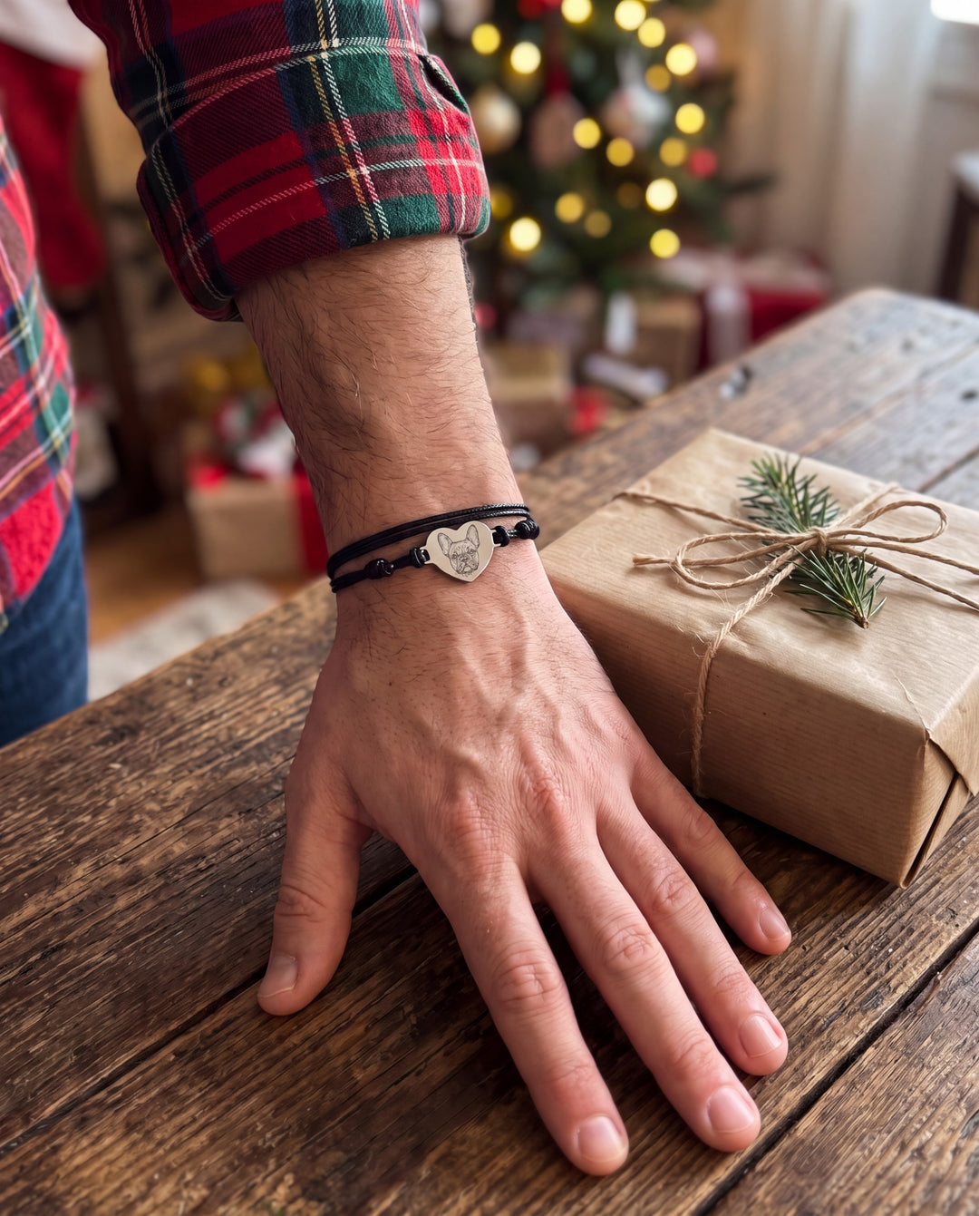 Man wearing the black cord pet portrait bracelet next to a wrapped Christmas gift