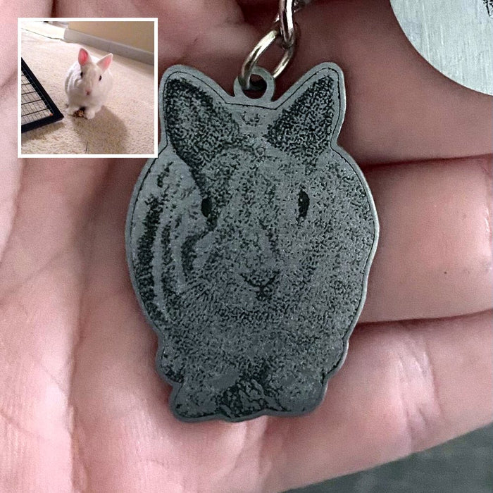 Customer holding an engraved rabbit keychain, with the photo of her rabbit