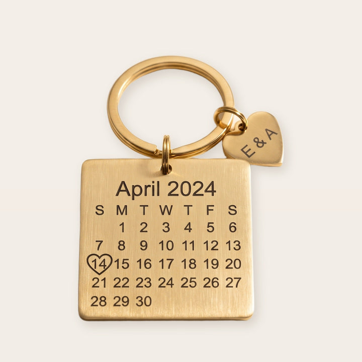 Personalized calendar keychain, gold tone, on a plain background