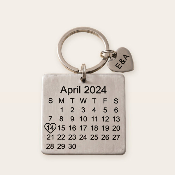 Personalized calendar keychain, silver tone, on a plain background