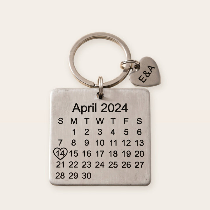 Personalized calendar keychain, silver tone, on a plain background