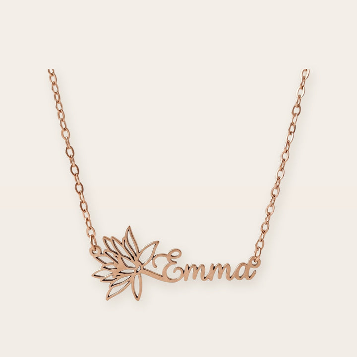 Birth flower name necklace, rose gold tone, on a plain background