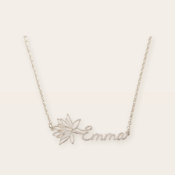 Birth flower name necklace, silver tone, on a plain background