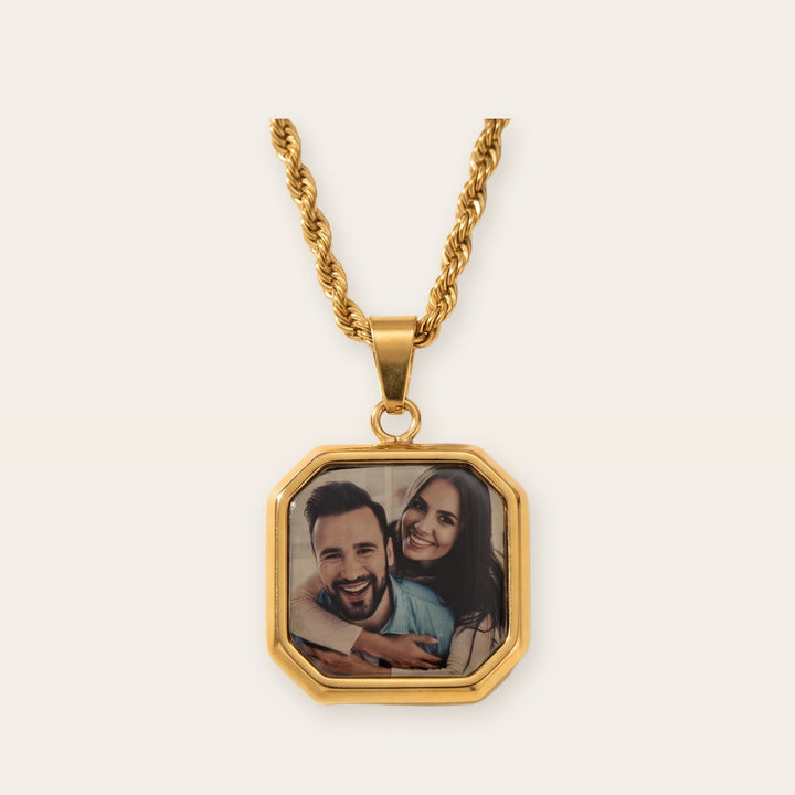Heat activated photo necklace, gold tone, on a plain background