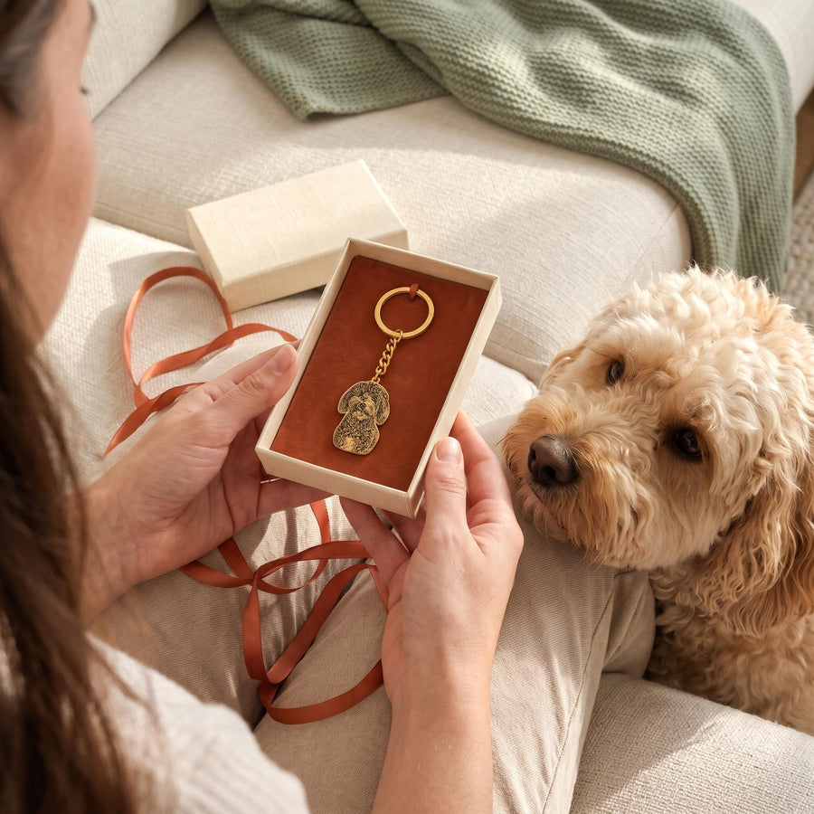 Opening a pet photo keychain gift with the dog nearby
