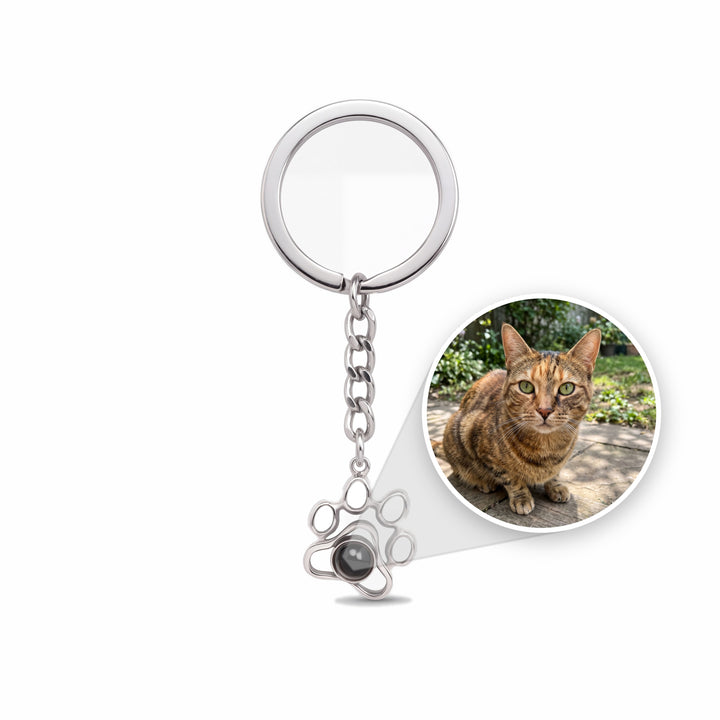 Paw projection keychain with a cat photo sealed inside the stone shown in a circle