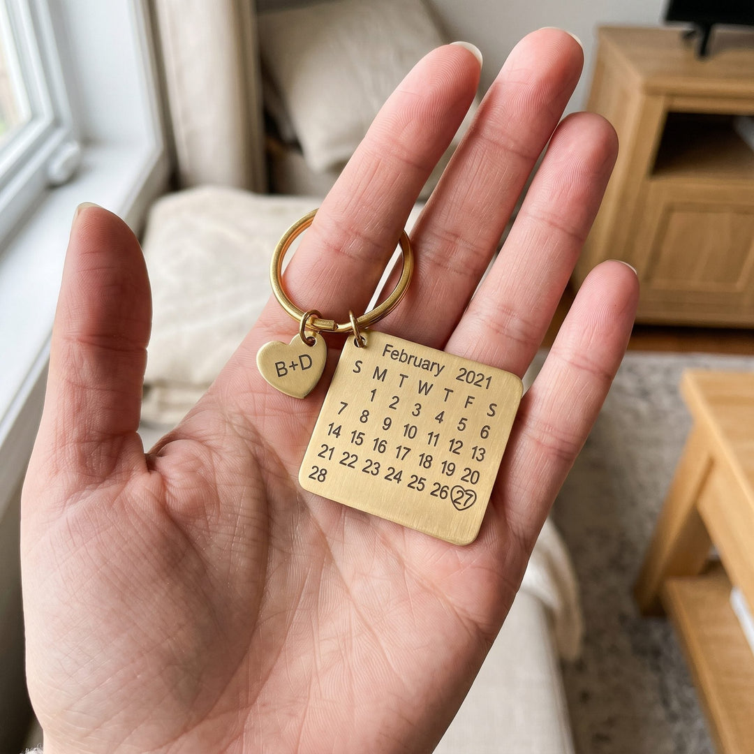personalized calendar keychain with an engraved date, held in a hand to show true size