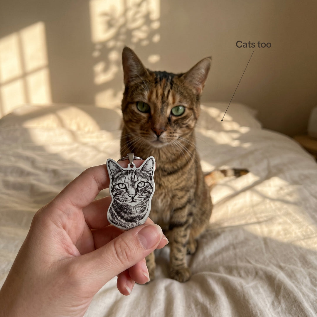 Silver cat photo keychain held in front of the tabby cat it shows