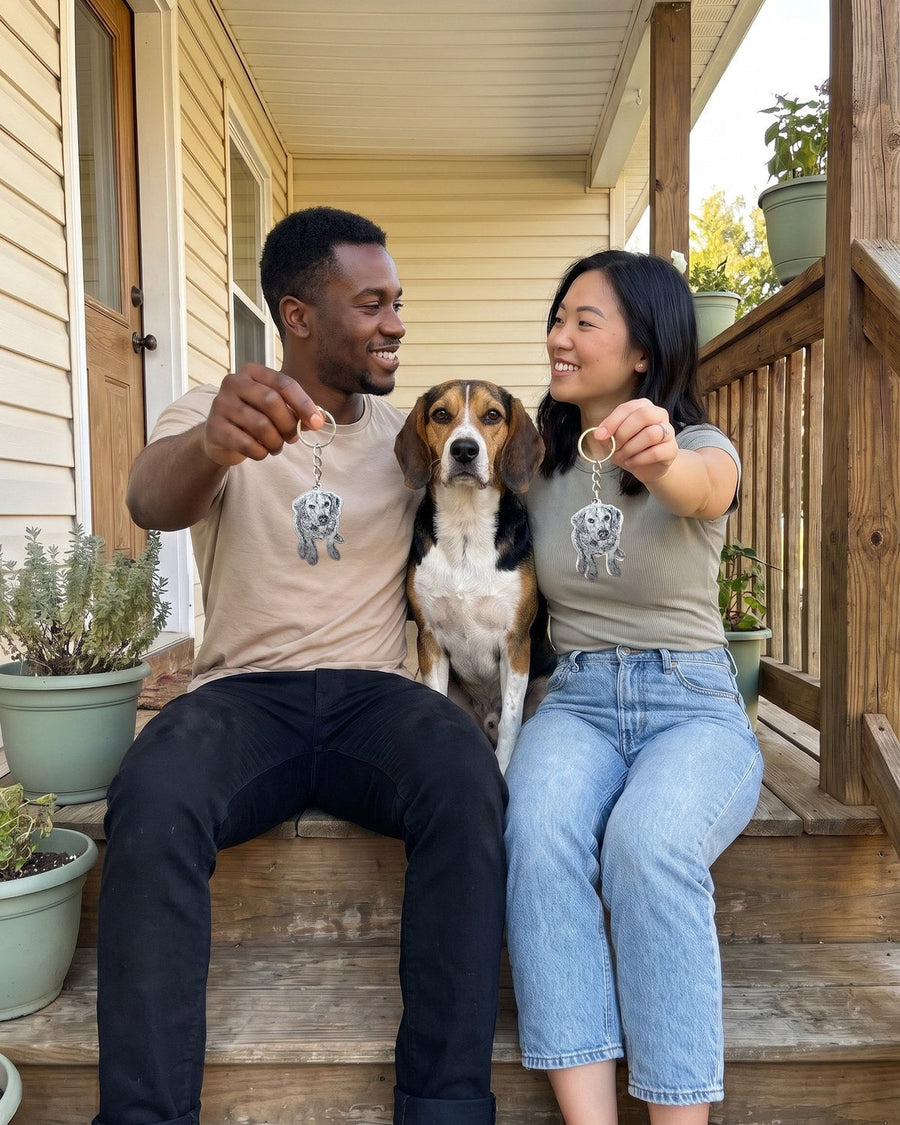 Couple on a porch holding matching engraved beagle keychains with their beagle between them